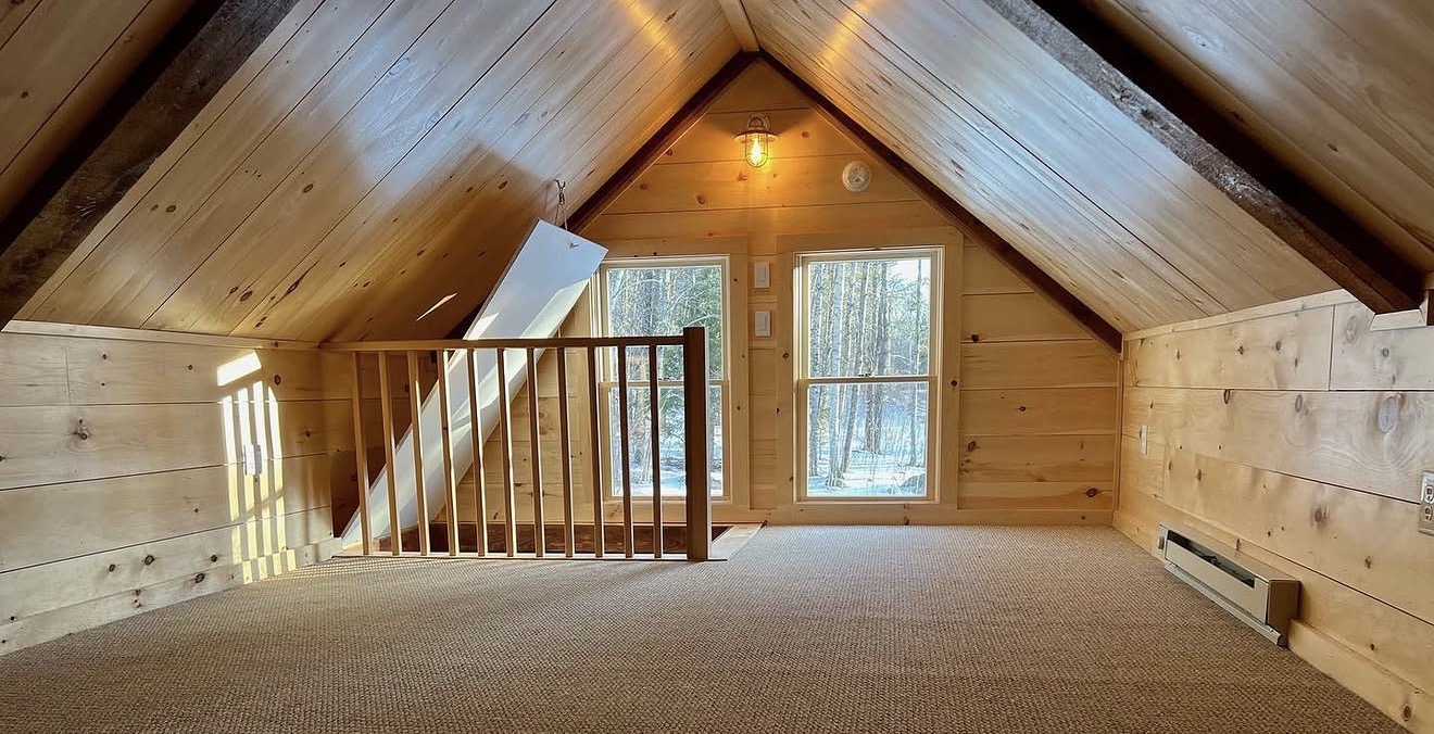 Knotty-pine attic loft conversion with cathedral ceiling and exposed beams in a New Hampshire home